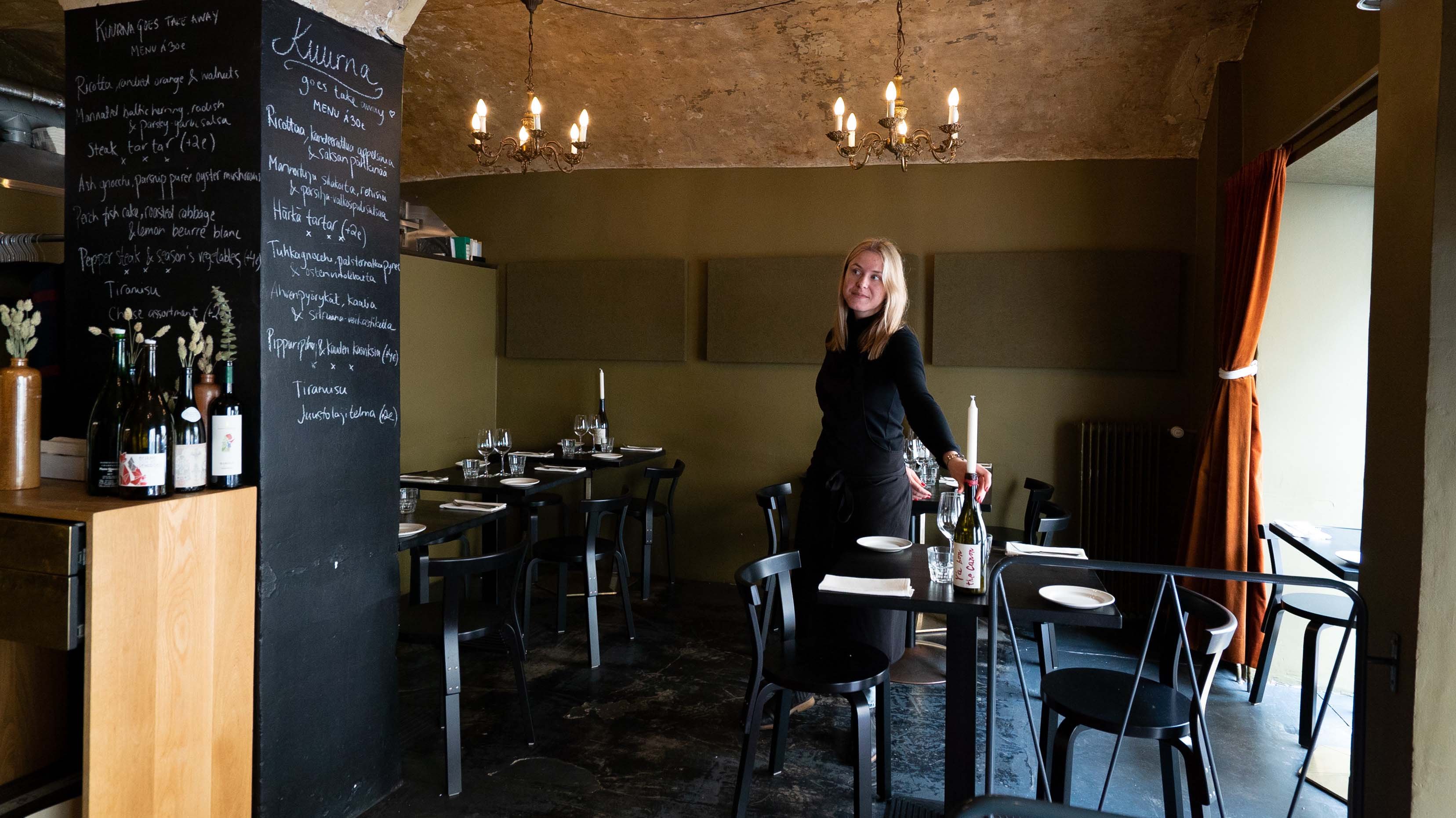 Ravintoloitsija Laura Hansen, joka seisoo ravintola Kuurnassa ja hymyilee.