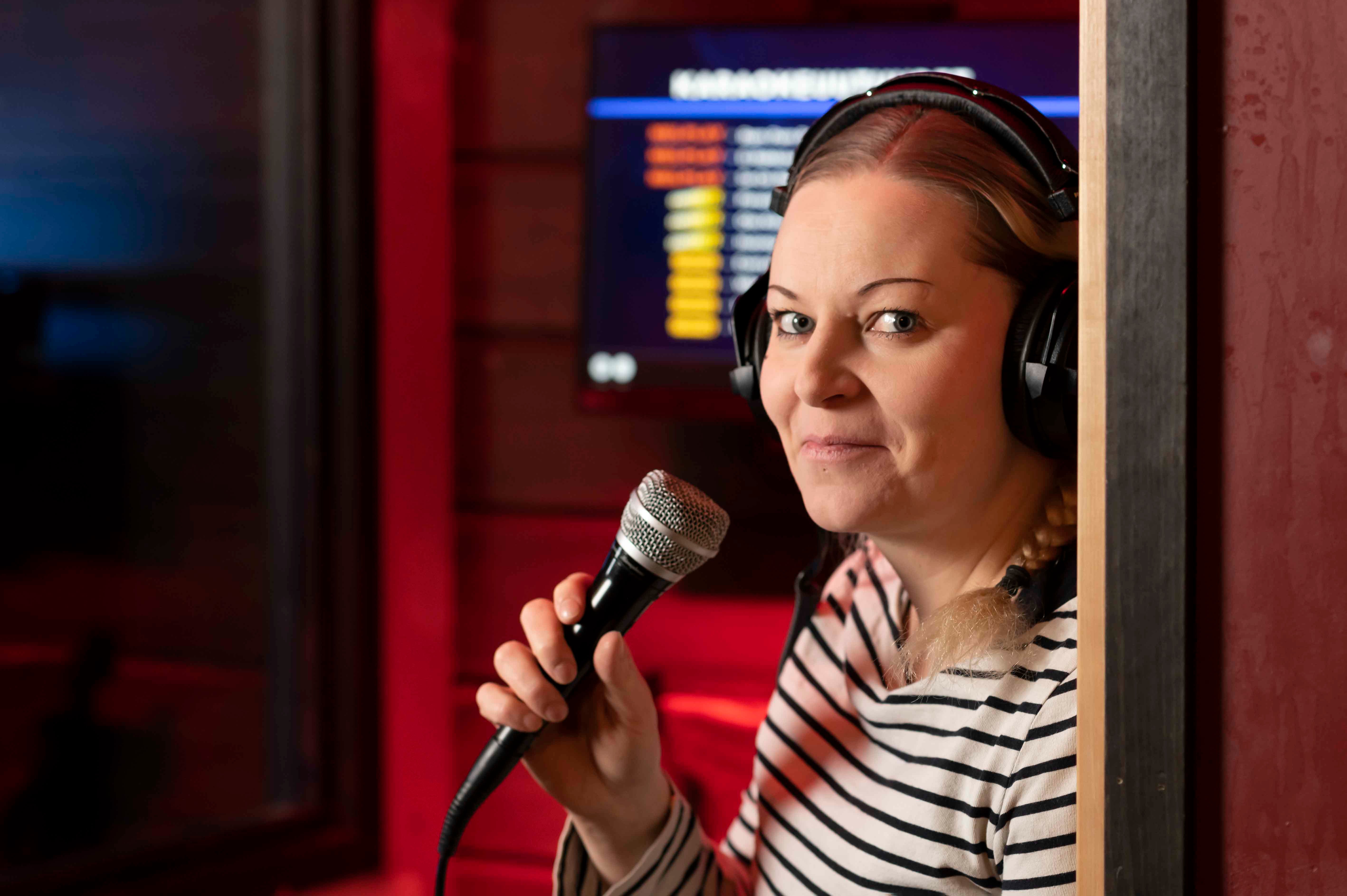 Jolene Kuopion ravintolapäällikkö Tiina Kettunen mikki kädessä ravintolan sisätiloissa.