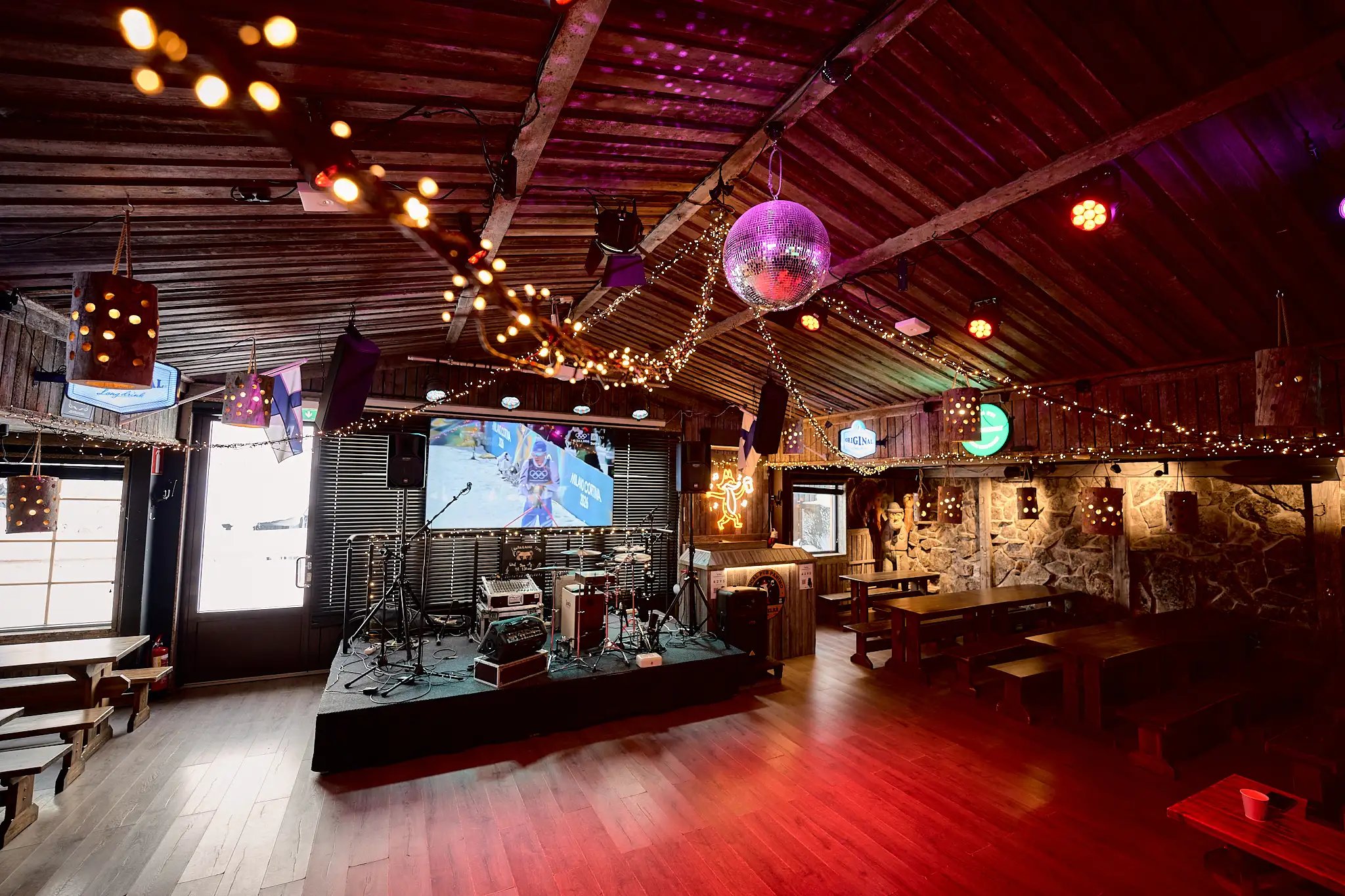 The restaurant’s dance floor and performance stage. In the background, a TV screen showing a sports broadcast.
