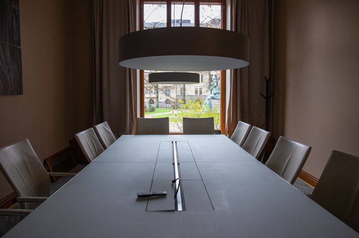 A meeting room with a long table and chairs.