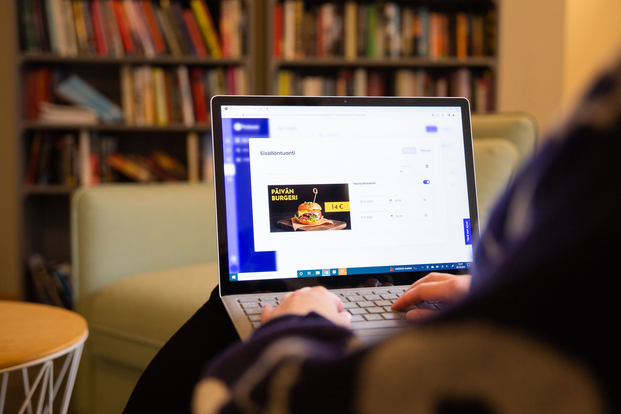A person holding a laptop in their lap, with the My Feelment website open.
