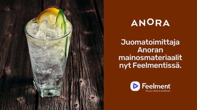 Juomalasi, jossa vaaleaa juotavaa sekä jäitä. Oikealla puolella teksti: "Juomatoimittaja Anoran mainosmateriaalit nyt Feelmentissä."