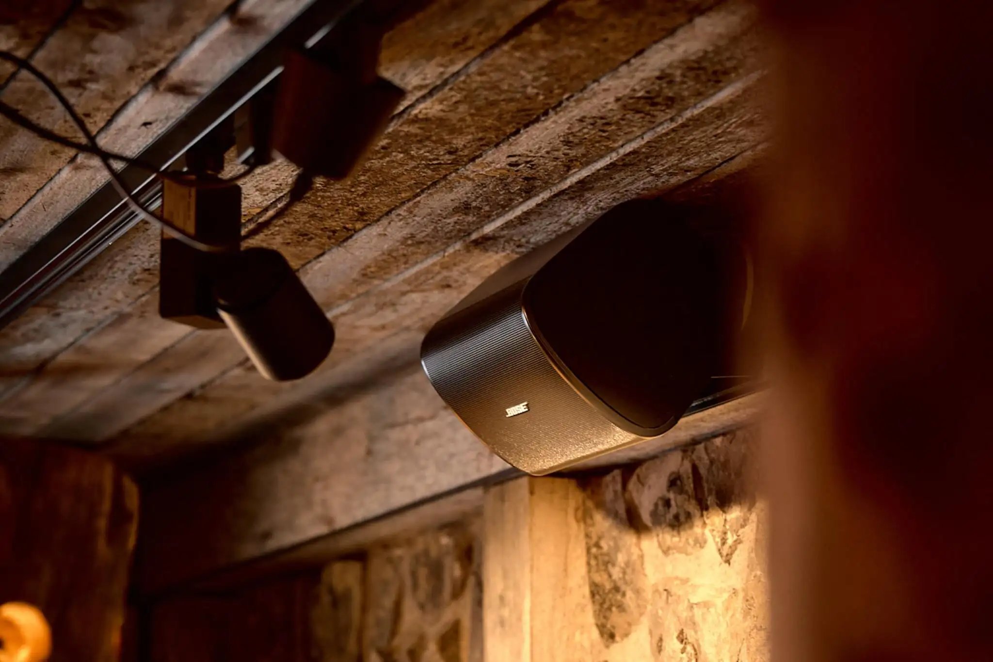 A Bose speaker mounted near the restaurant ceiling.