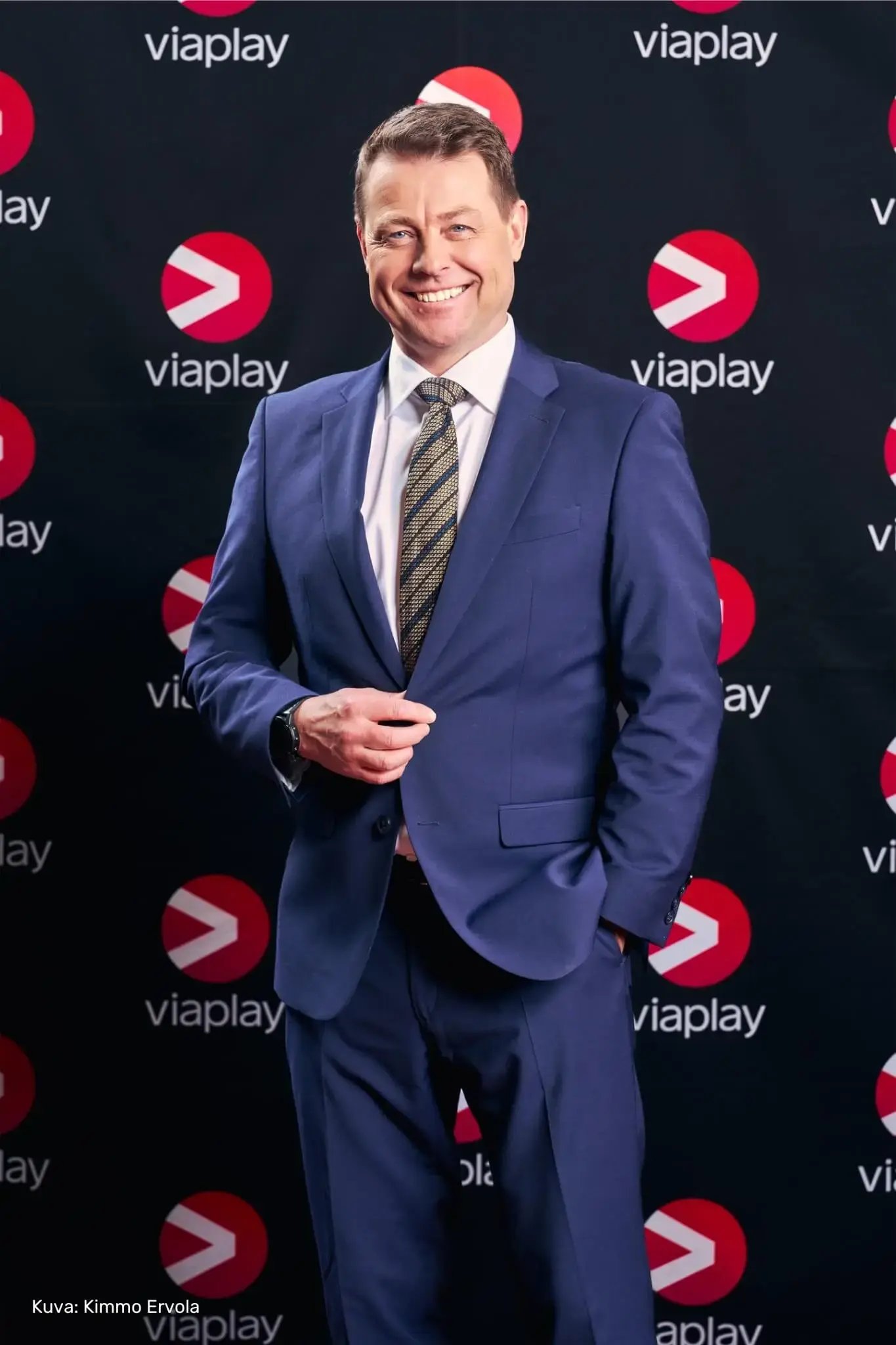 Viaplayn urheiluasiantuntija Ville Klinga sinisessa puvussa. Taustalla tumma kangas, jossa Viaplayn logoja.