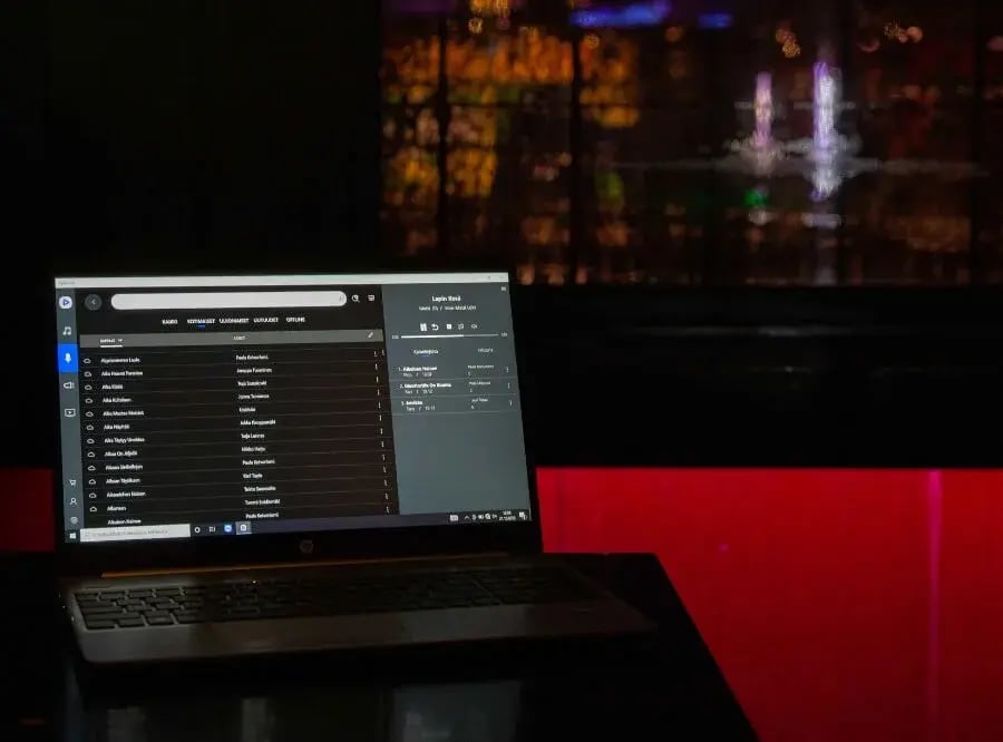 Ruskealla puupöydällä oleva läppäri, jossa näkyy Feelmentin karaokesovellus.