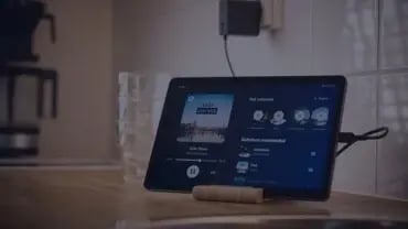 Pöydällä oleva tabletti, jossa avoimena Feelmentin sovellus. Tabletin takana juomalaseja ja kahvinkeitin.