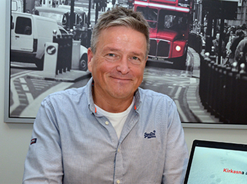 A smiling man sitting down. 