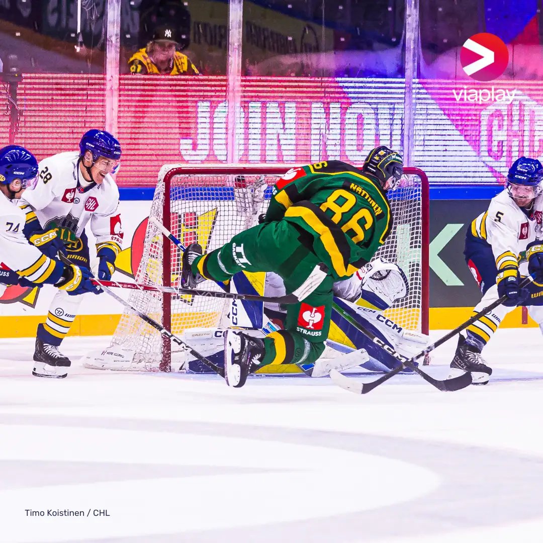 Ice hockey players battling for the puck in front of the goal.