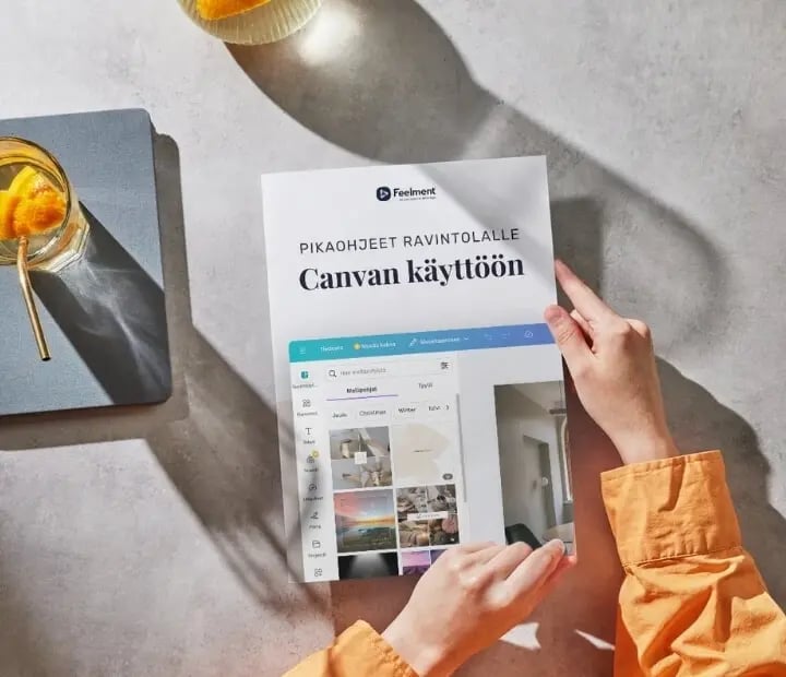 Henkilö pitelemässä lehtistä, jonka kannessa teksti 