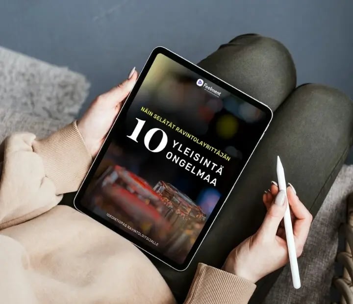 Naisen käsissä oleva tabletti, jossa näkyy teksti