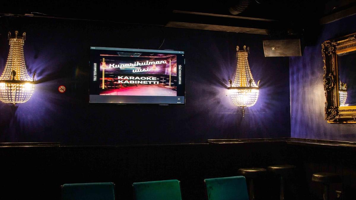 The restaurant space with a TV on the wall. The screen displays the text 'Karaoke Room.