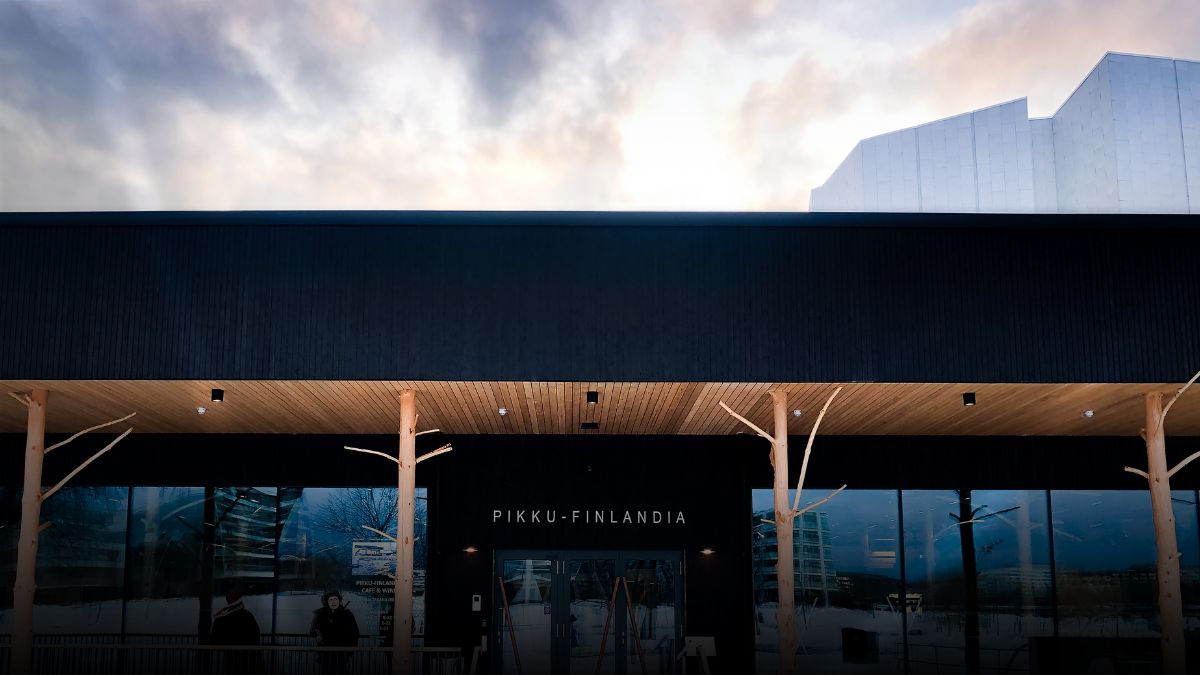 The main entrance of Little Finlandia and a terrace with two people standing.