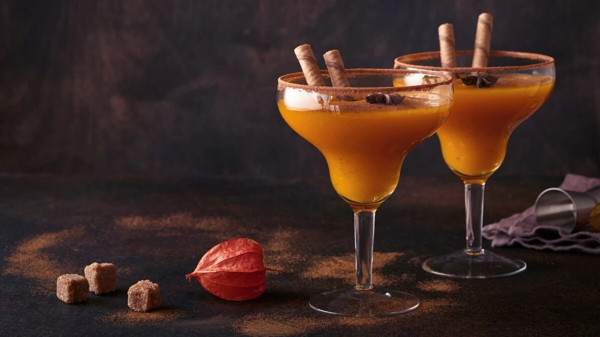 Kaksi lasia, joissa on oranssinväristä juotavaa.