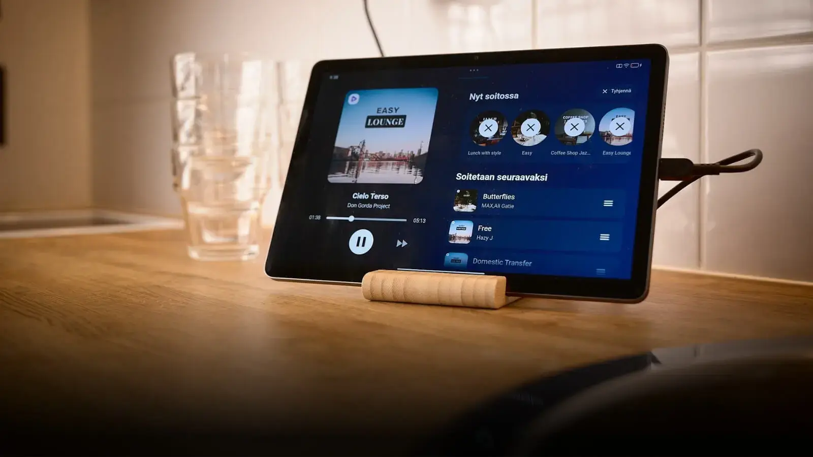 Puisella pöydällä oleva tabletti, jossa käytössä Feelmentin sovellus. Tabletin vieressä on juomalaseja.