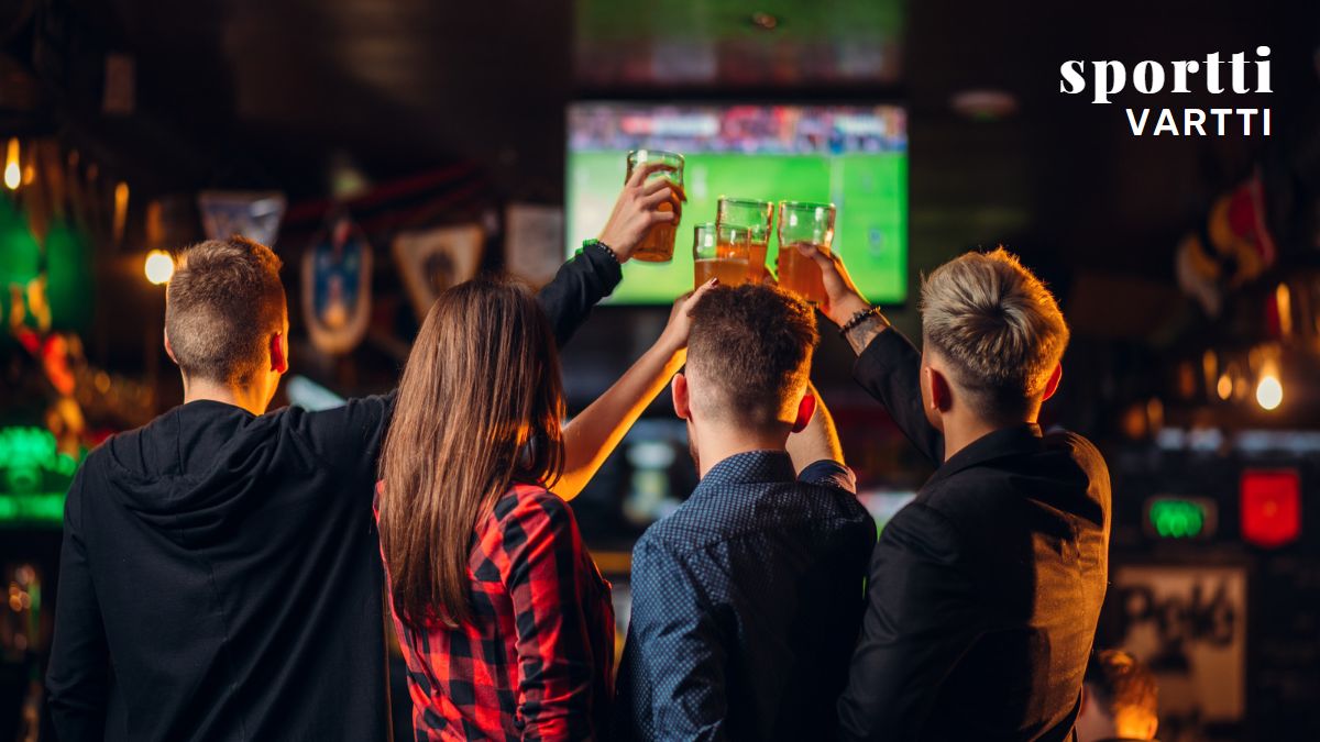 People in a restaurant watching sports and toasting their drinks.