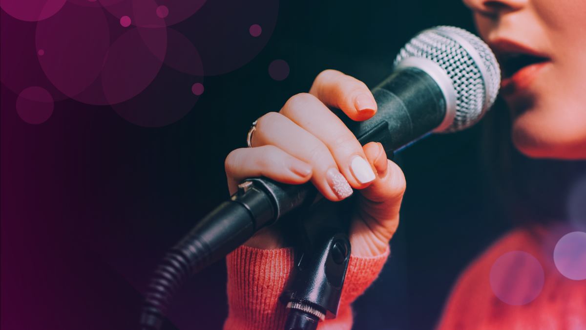 Woman singing to a microphone.