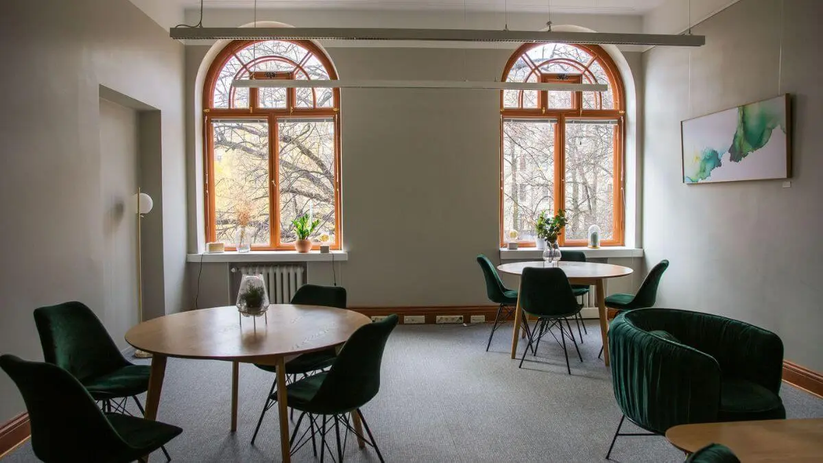 A working space with round tables and green chairs.