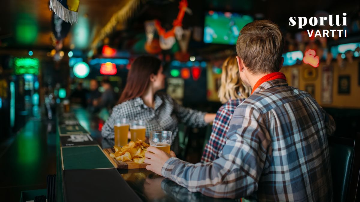 People in a restaurant watching sports.